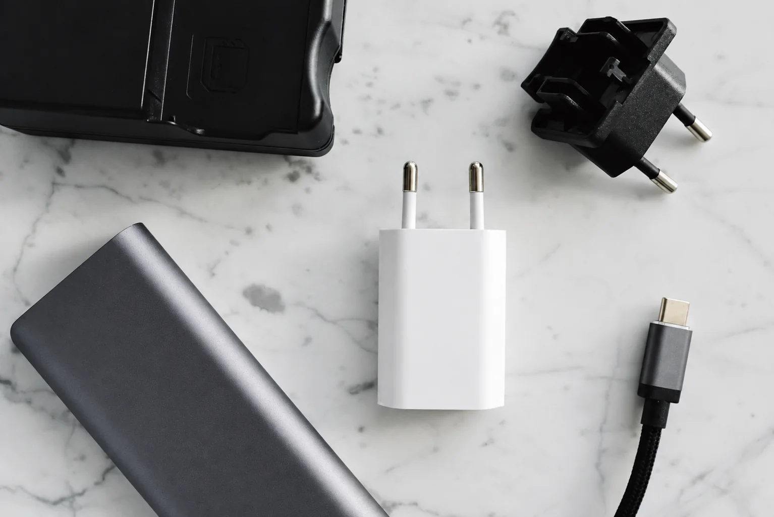 Power adapters and a USB-C hub on a marble surface.