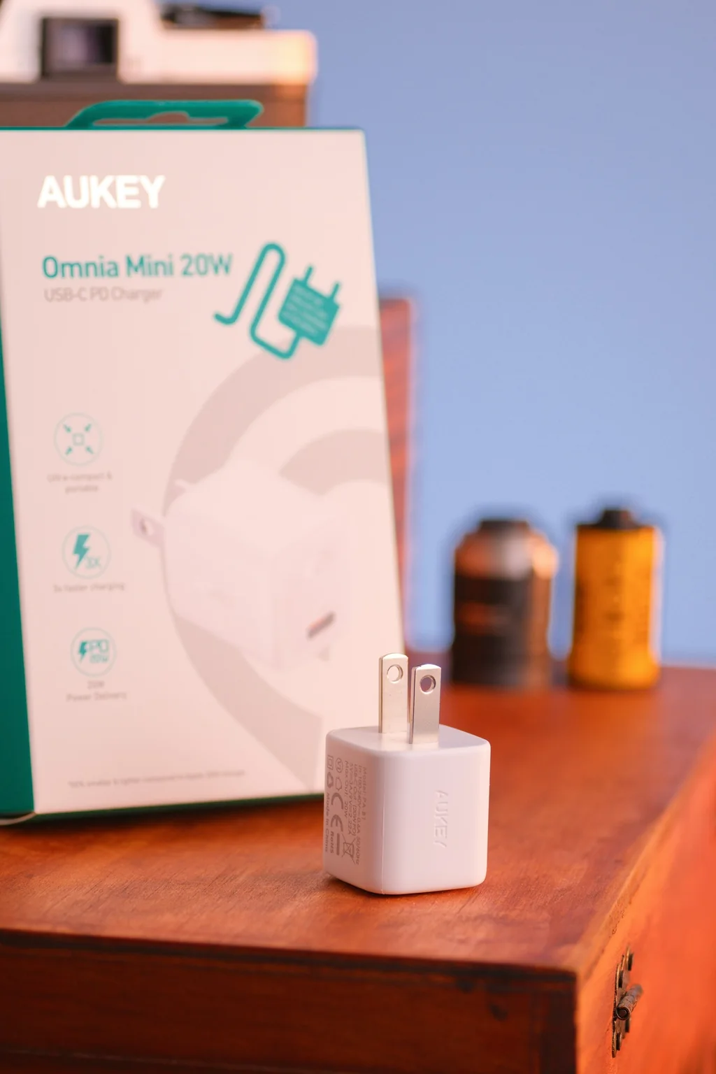 An AUKEY Omnia Mini charger beside its retail box on a wooden surface.